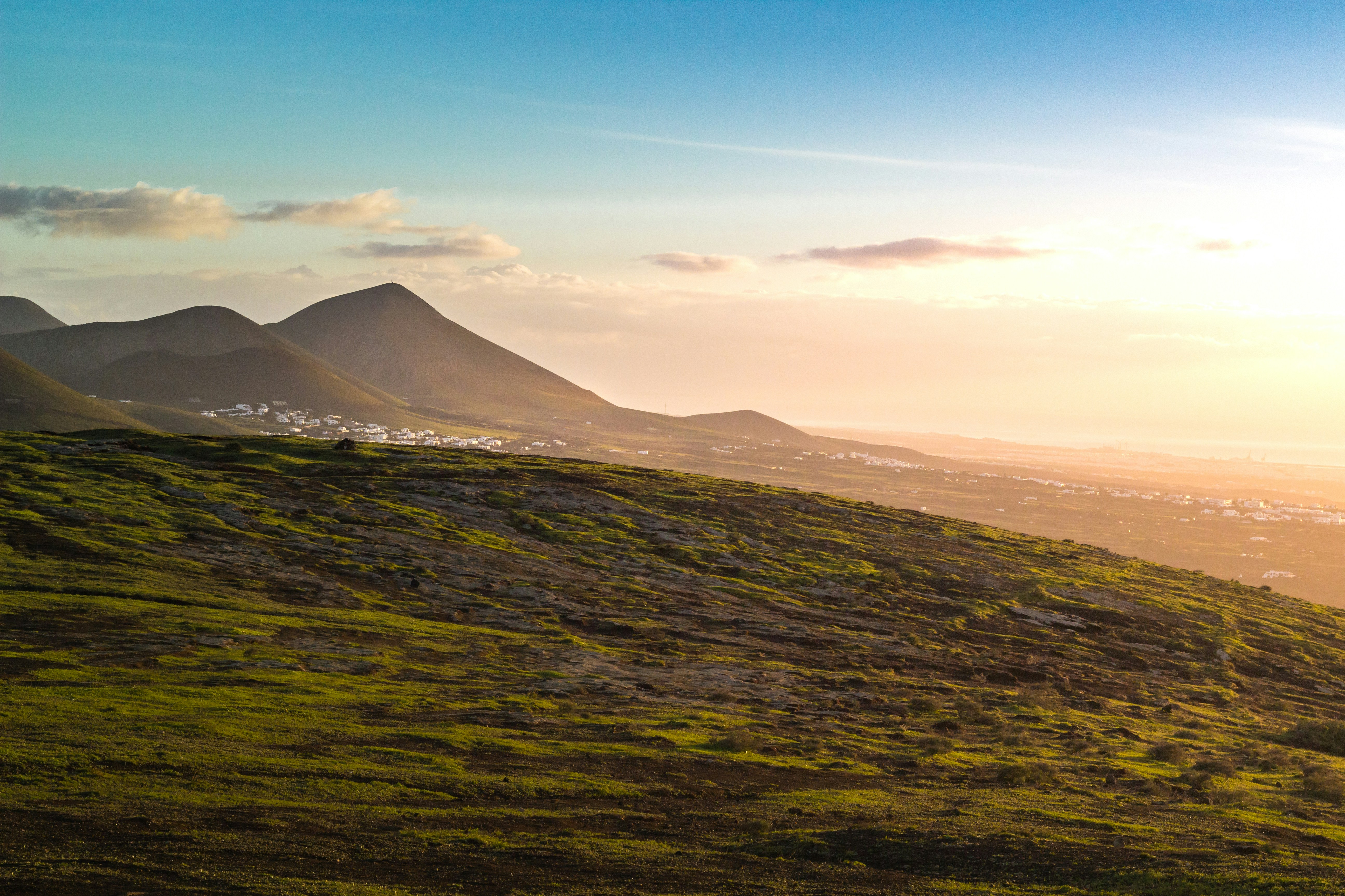 a grassy hill with a mountain in the background