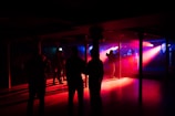 a group of people standing in a room with a red light