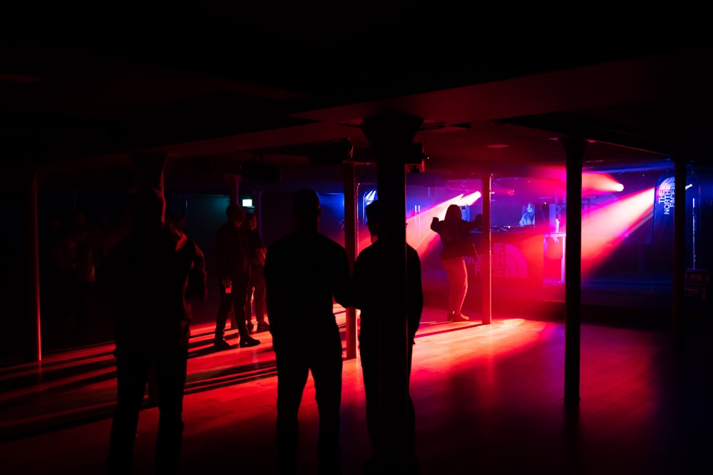a group of people standing in a room with a red light
