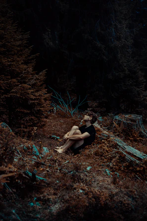 Participants seated peacefully on forest floor mats, surrounded by autumn foliage.