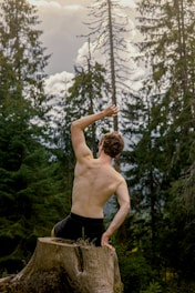 a shirtless man holding a rope