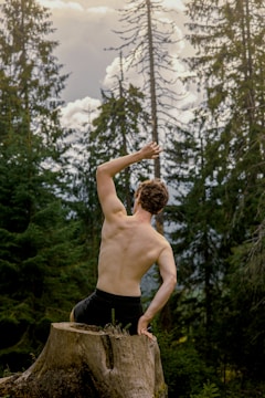 a shirtless man holding a rope