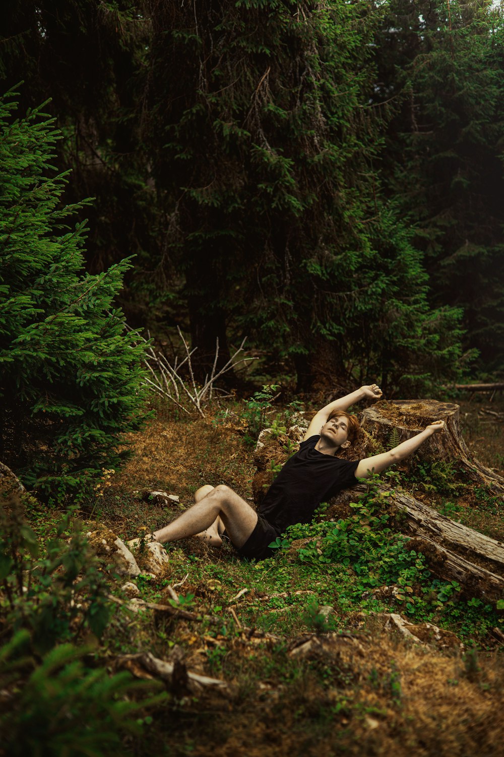 a person lying on the ground in the woods