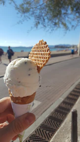 Family enjoying ice cream together on a sunny Belgian beach with soft waves in background
