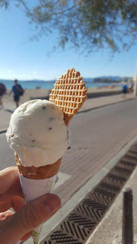 Family enjoying ice cream together on a sunny Belgian beach with soft waves in background