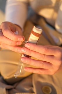Close-up of hands gently unwrapping a beautifully packaged odeia item.
