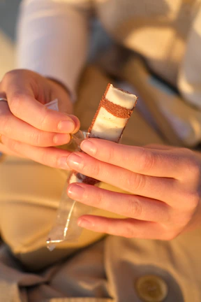 Joyful hands unwrapping a seasonal dessert collection gift with playful pastel wrapping.