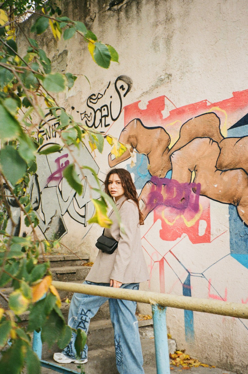 a person standing next to a wall with graffiti
