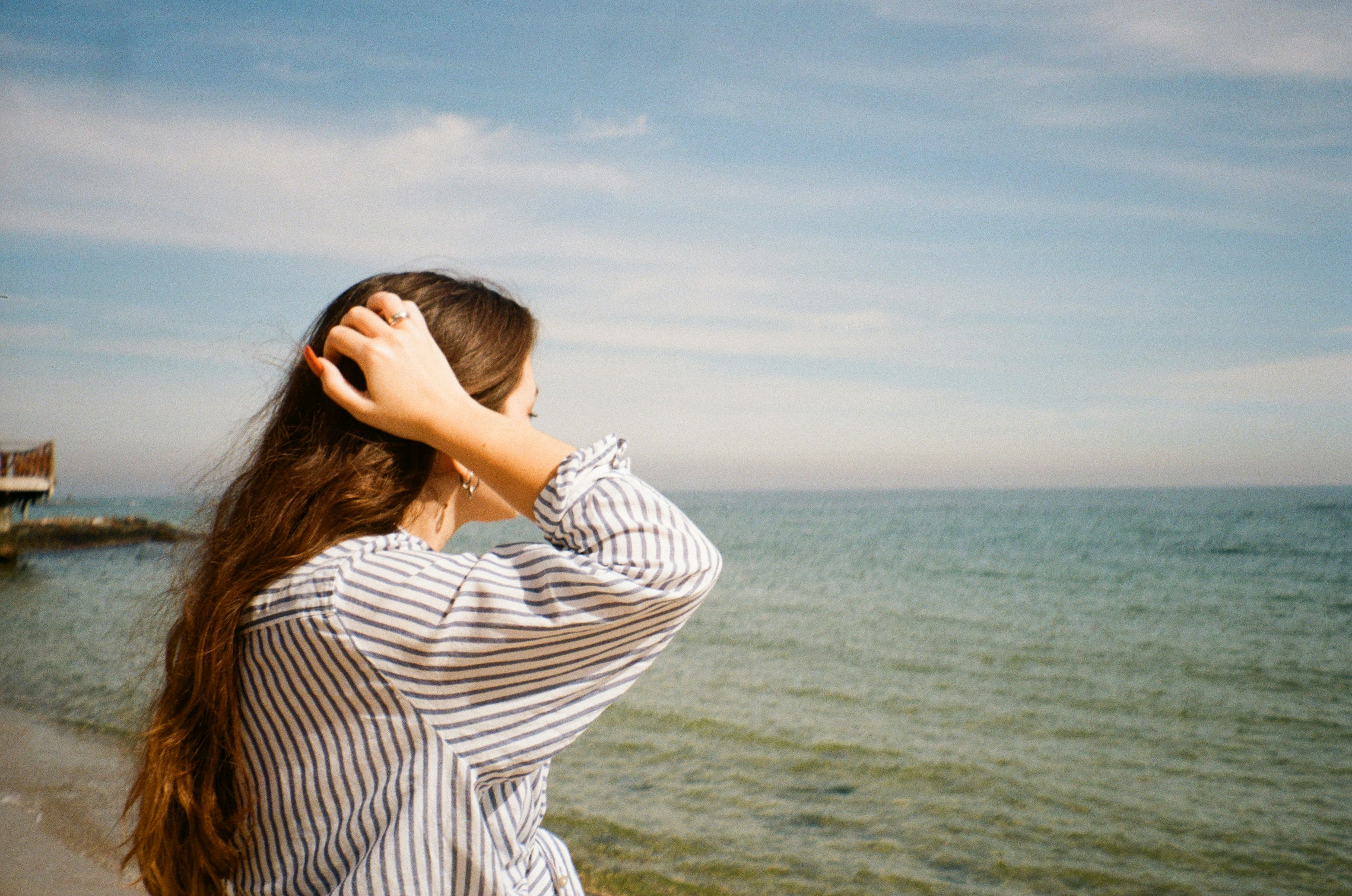 a person with the head in the hands looking at the water