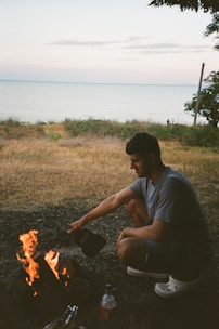 A person purifying water by a campfire in a wilderness setting.
