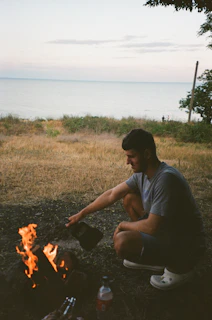A serene outdoor scene showing a person practicing fire-starting skills with natural materials.