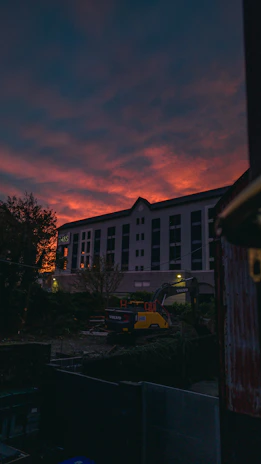 Industrial generator set powering a large construction site at dusk with glowing lights.