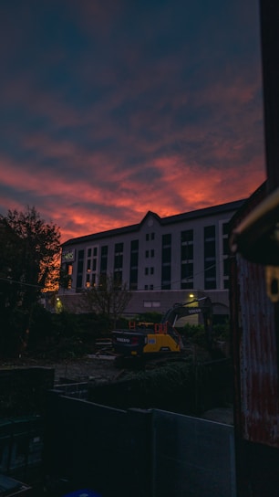 A heavy excavator at work on a construction site during sunset.