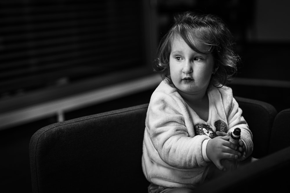 a little girl sitting on a couch