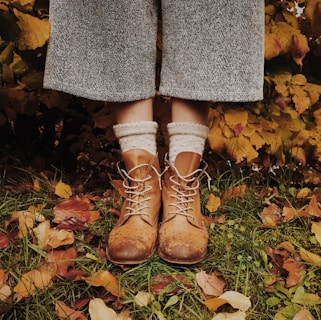 Wool socks being worn outdoors, with a backdrop of autumn leaves and hiking boots.