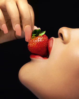 a hand holding a strawberry