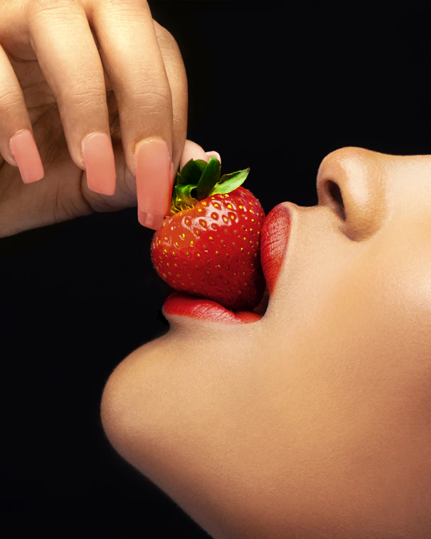 a hand holding a strawberry
