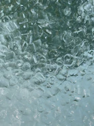 Close-up of clear crushed ice glistening under soft light