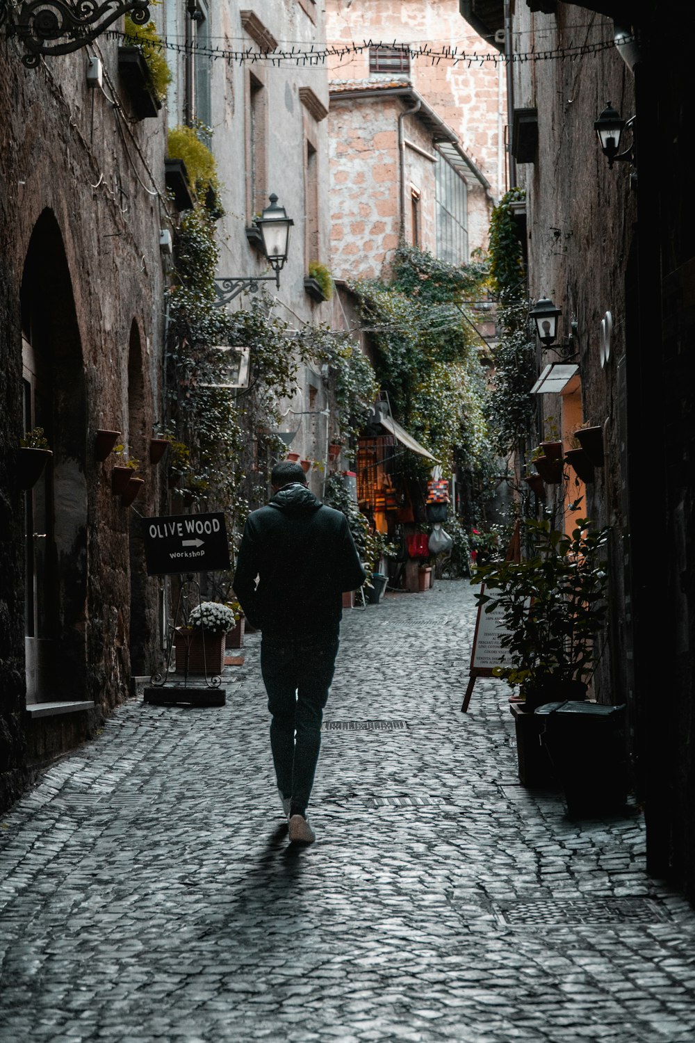 a man walking down a narrow street
