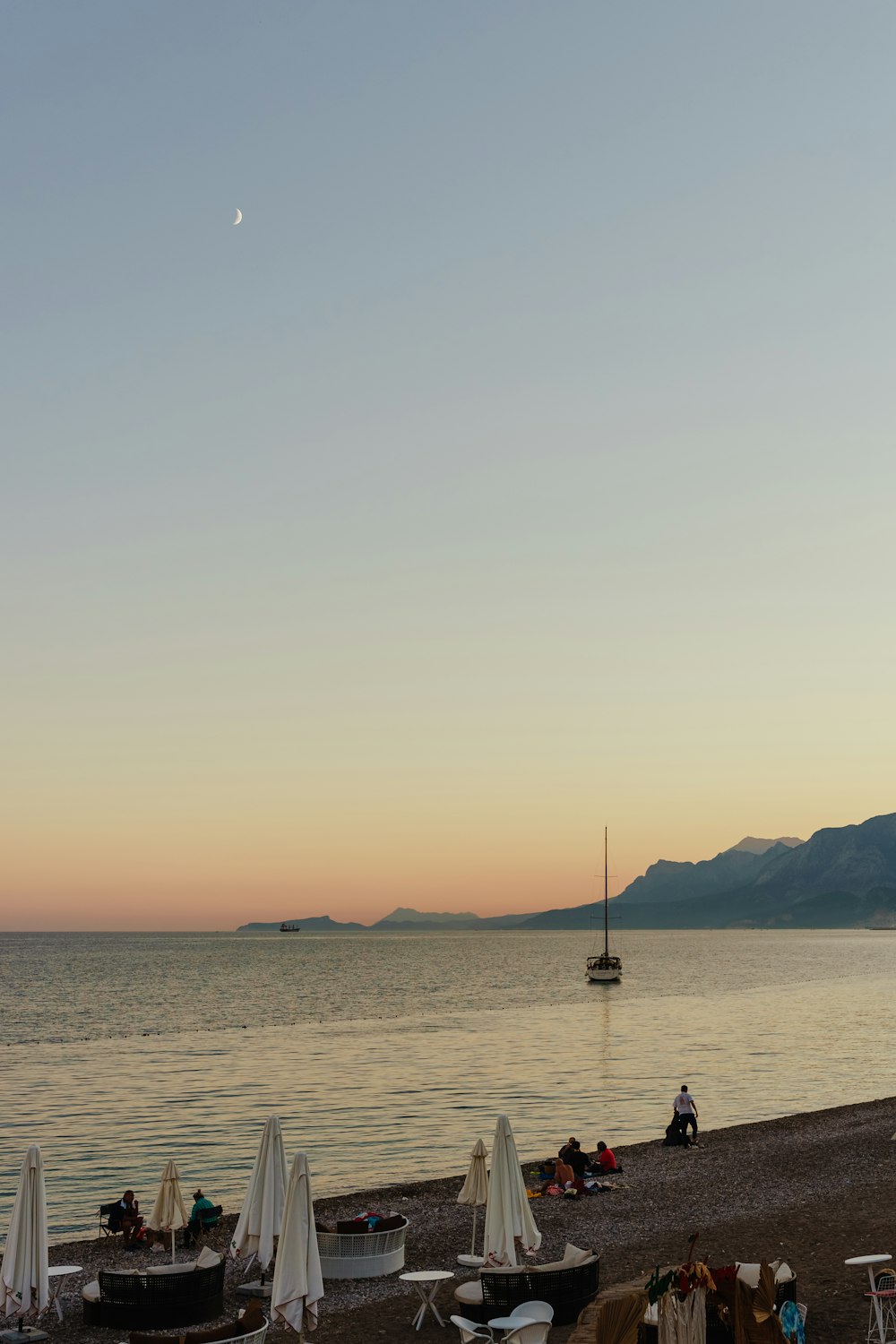 a beach with boats and umbrellas