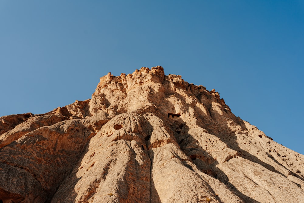 a rocky mountain with a blue sky