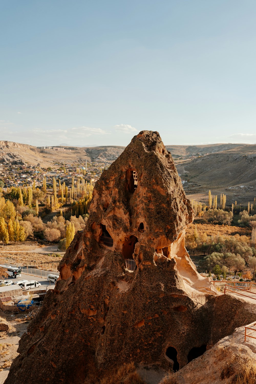 una grande formazione rocciosa con una strada e alberi sullo sfondo