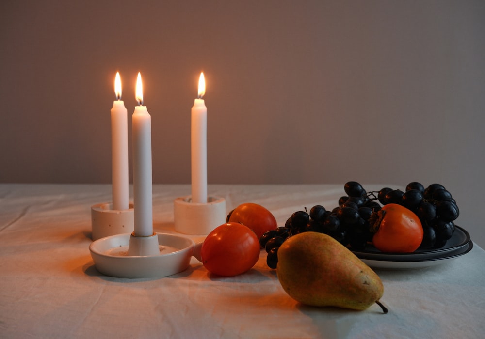 a plate of fruits and candles