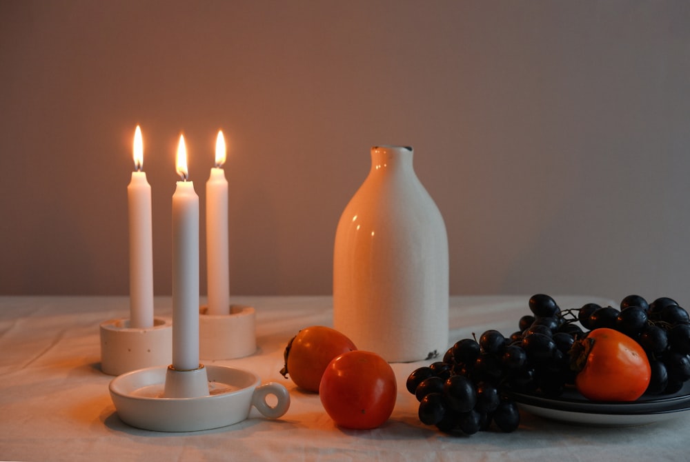 a group of candles and fruit