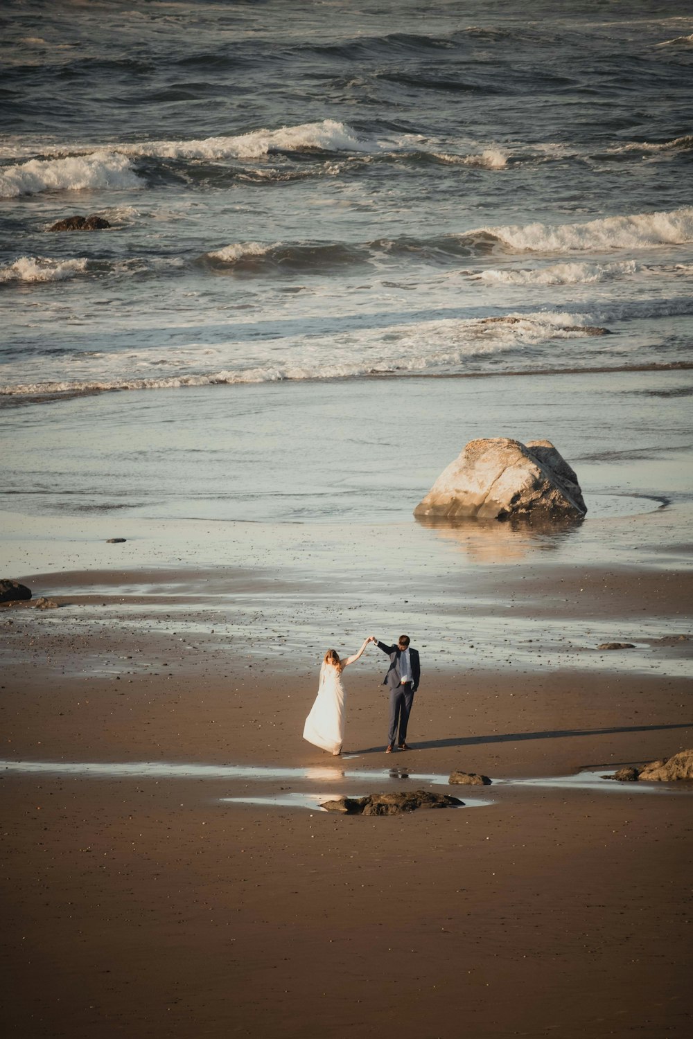 a bride and groom on the beach