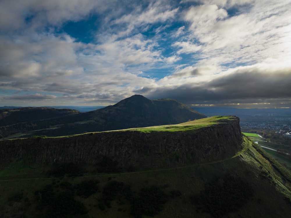 a landscape with hills and a body of water in the background