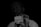 A person holds a card close to the camera, with a focused, serious expression. The card reads 'we are NATION Empower Africa' with a dark background that contrasts with the white text and card. The lighting highlights the card more than the person's face.