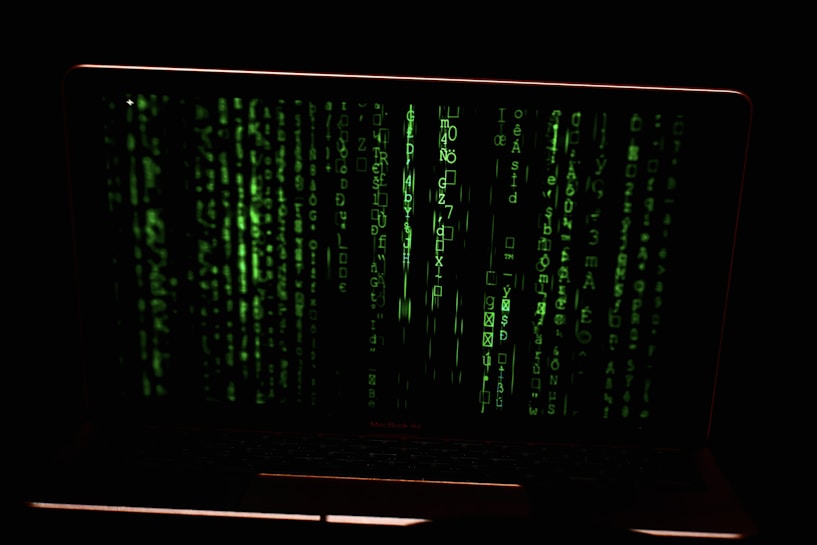 Green digital code streams vertically across the screen, resembling a hacker or cyber interface against a dark background.
