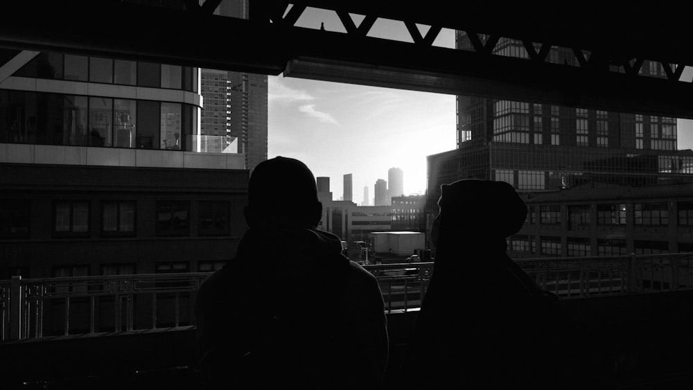 a couple people looking out a window