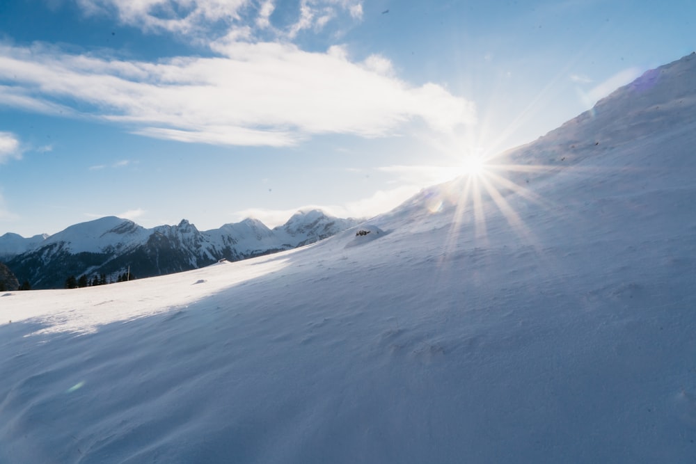 a snowy mountain with the sun shining