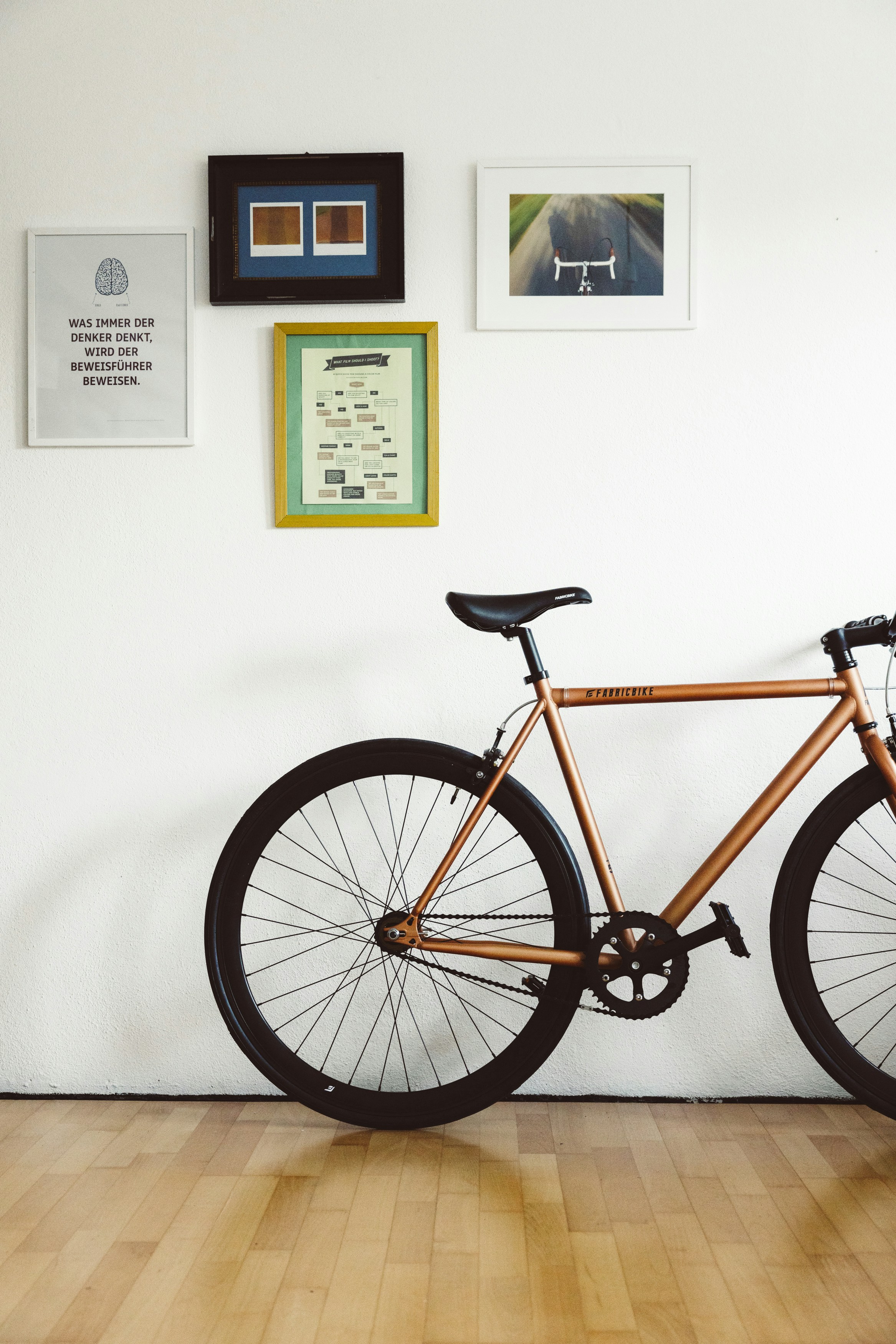 a bicycle in a room with pictures on the wall