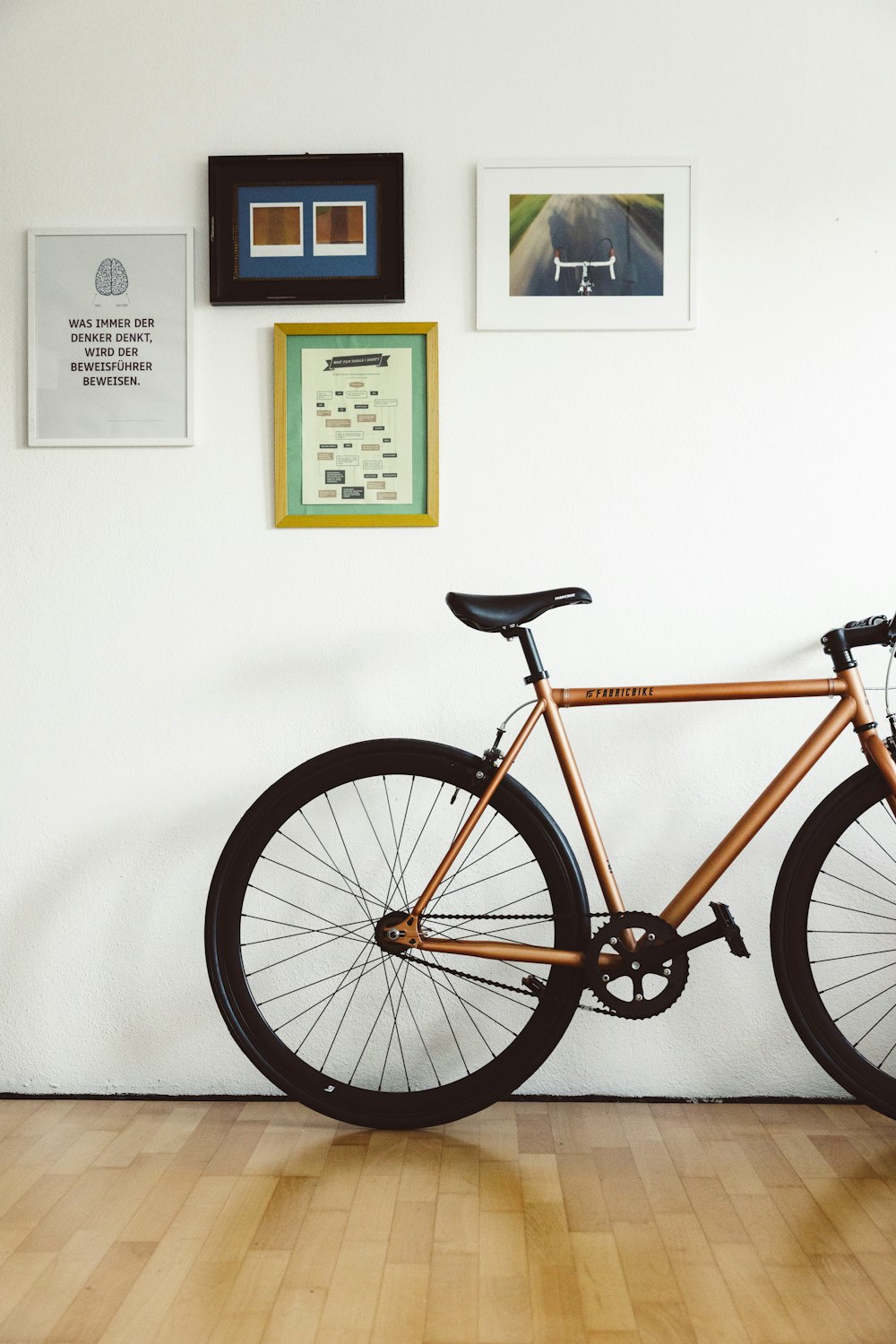 a bicycle in a room with pictures on the wall