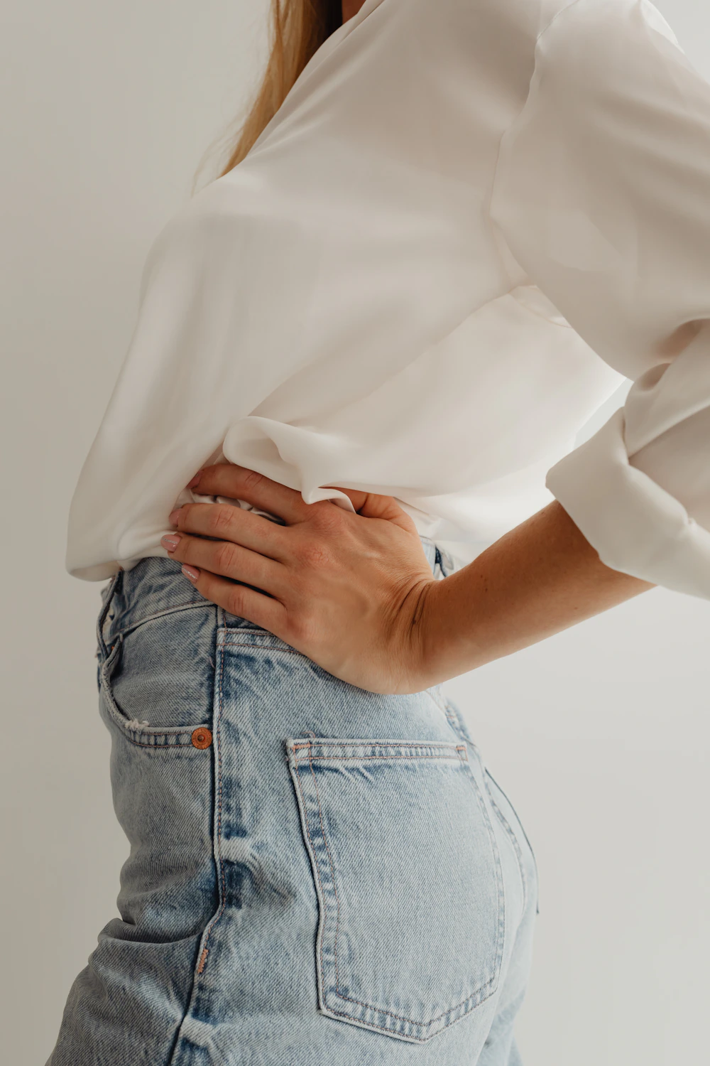 Model wearing a white shirt tucked into jeans
