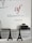 Wall signage featuring the Alliance Française logo in red and grey with the word 'Armenia' below. A minimalist office setting with grey cabinets, a printer on one side, and decorative models of the Eiffel Tower on a desk.