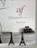 Wall signage featuring the Alliance Française logo in red and grey with the word 'Armenia' below. A minimalist office setting with grey cabinets, a printer on one side, and decorative models of the Eiffel Tower on a desk.
