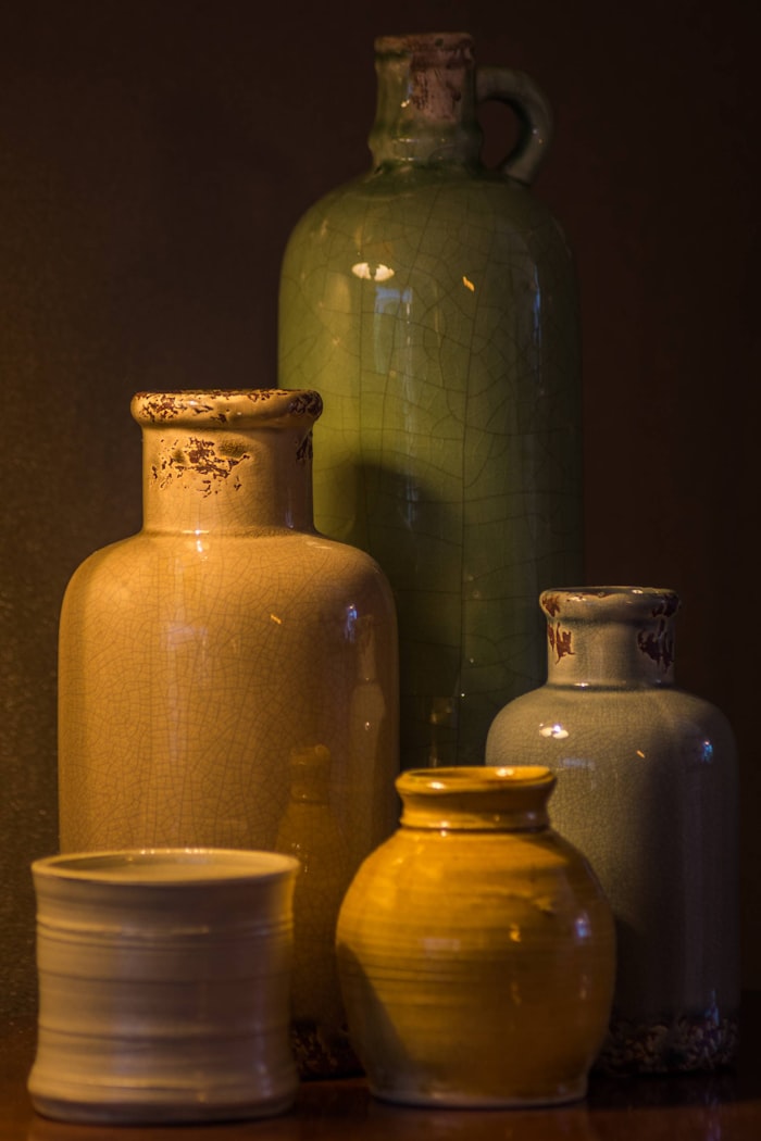 Ceramic vessels on a shelf by Jan-Willem van Braak on Unsplash
