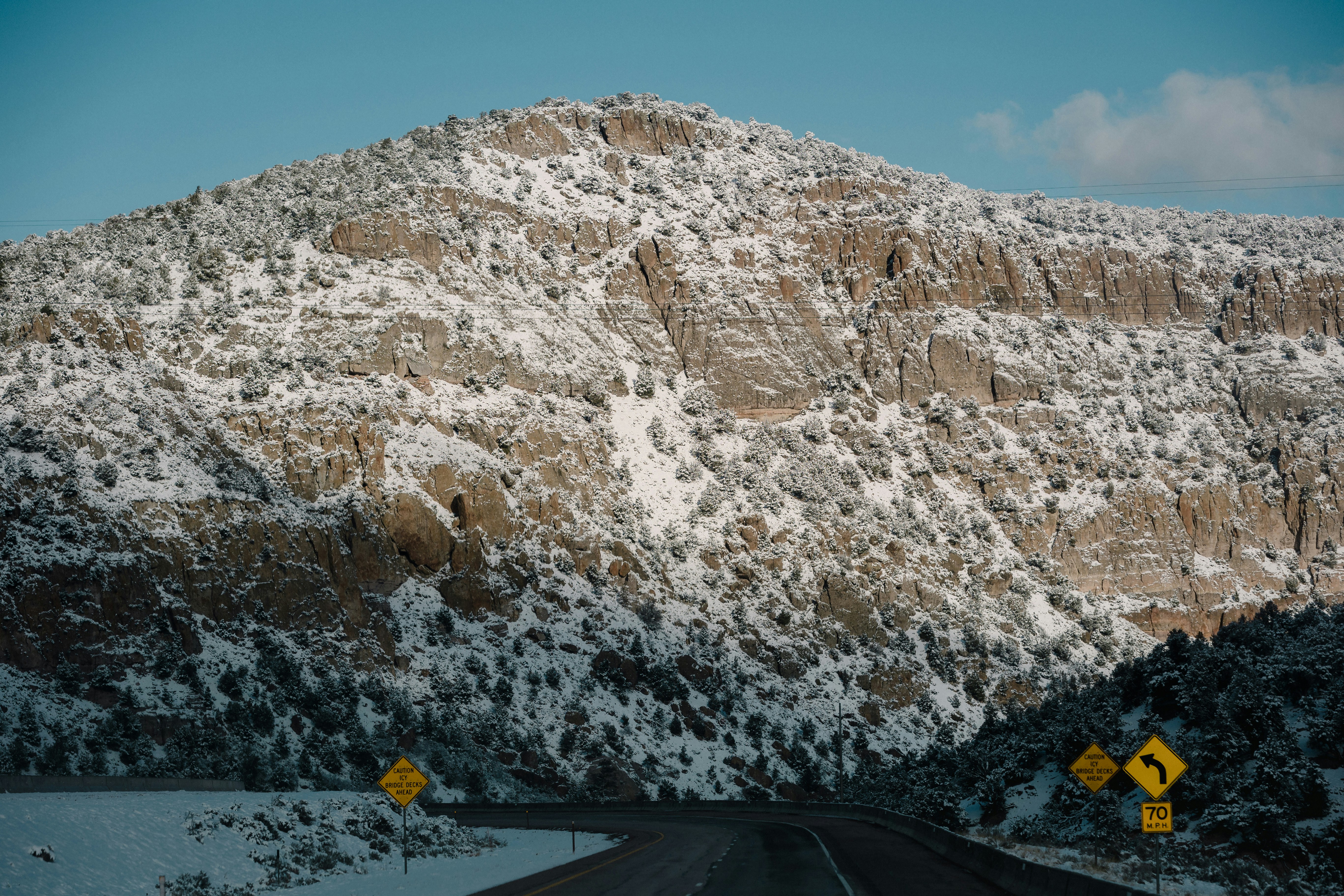 a road with a rocky mountain in the background