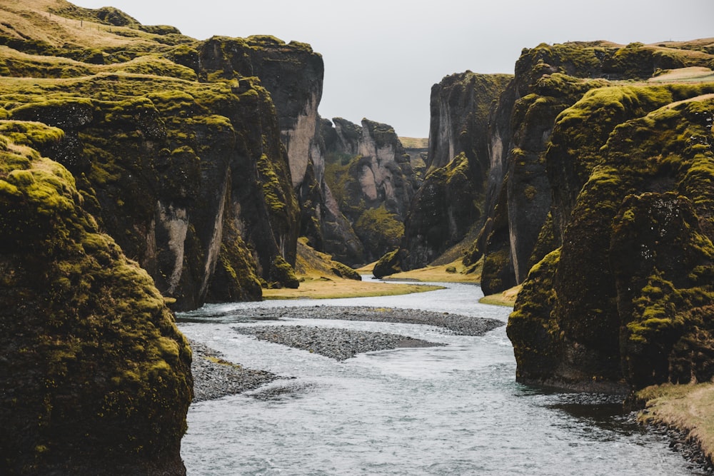 a rocky cliff with a river running through it