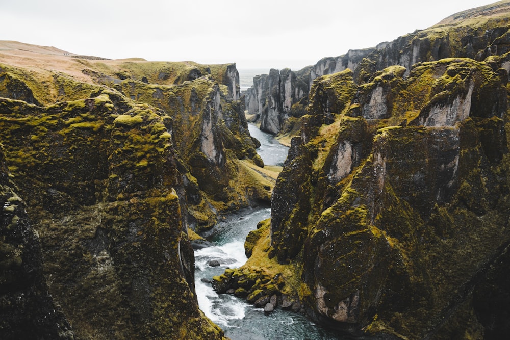 a rocky cliff with a river running through it