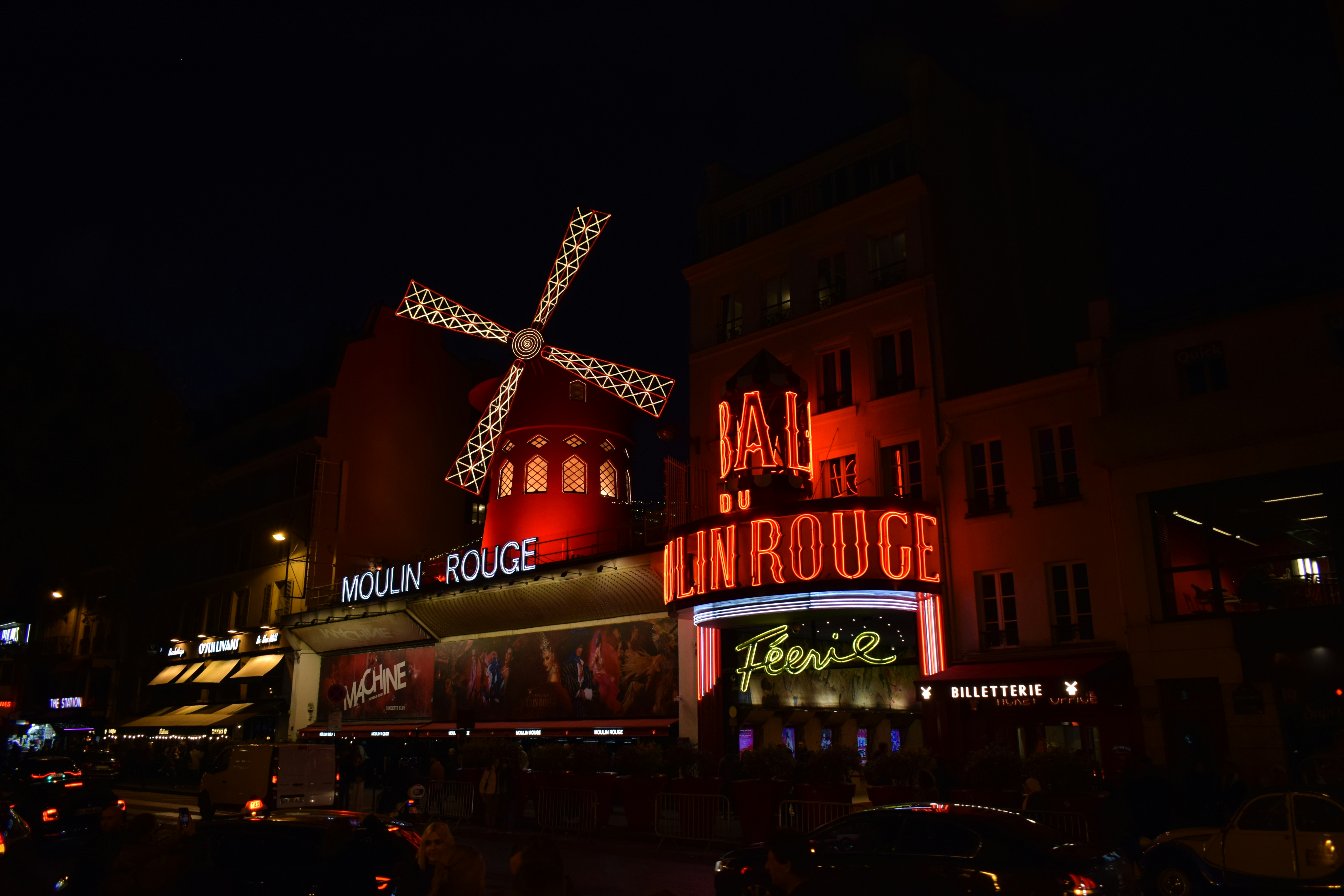 A group of buildings with neon signs with Moulin Rouge in the ...