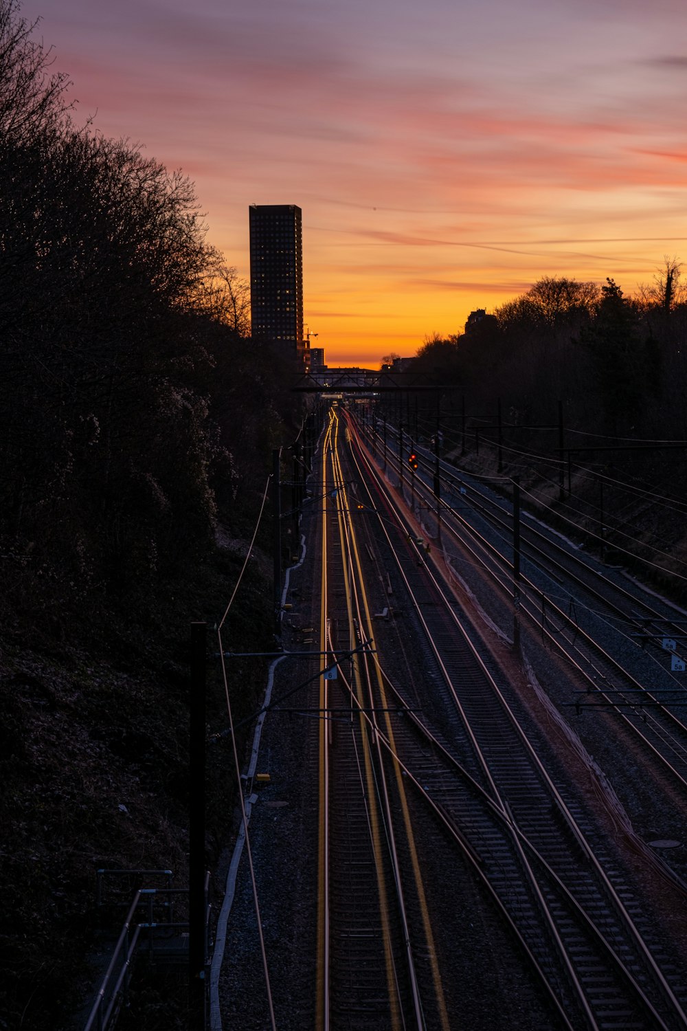 train tracks with a tall building in the background