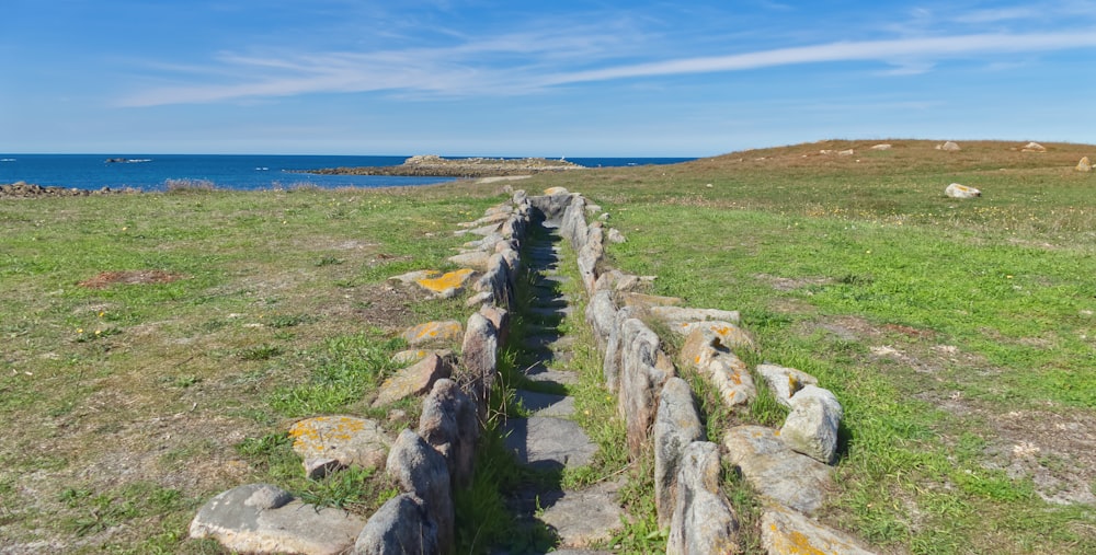 a stone wall on a grassy hill