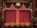 An ornate theater stage with rich burgundy curtains adorned with gold tassels and decorative patterns. The emblem above the curtains adds a touch of elegance to the classical setting. Wooden panels frame the sides, enhancing the traditional atmosphere.