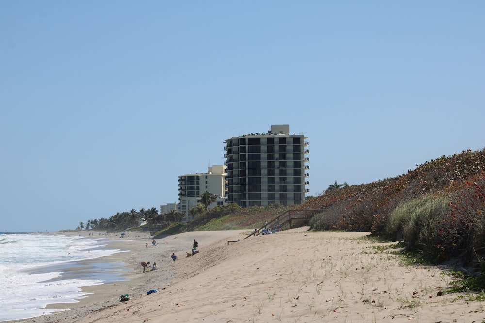 a beach with people and buildings in the background