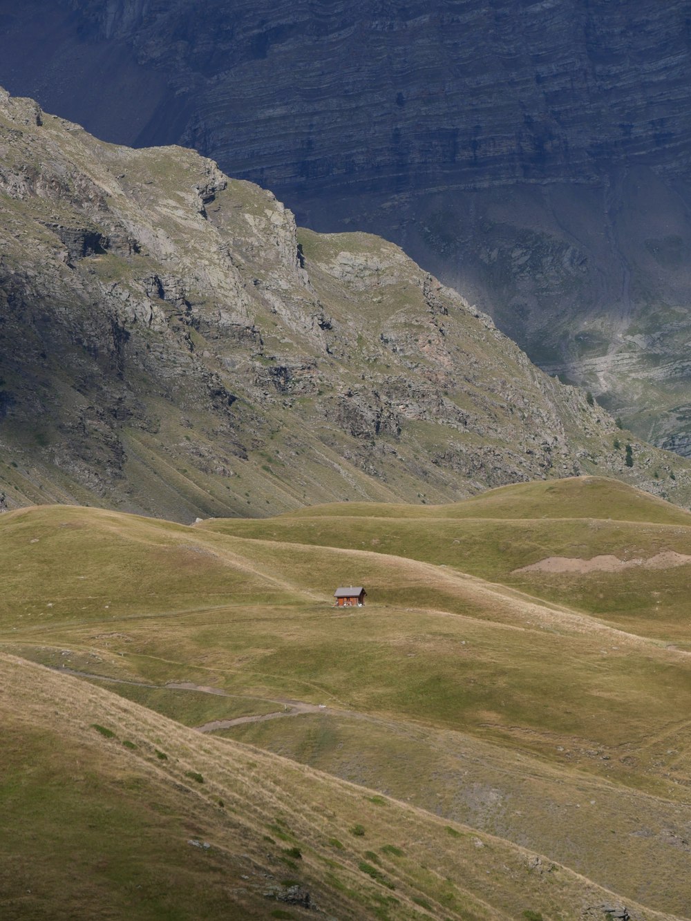 a car driving on a road in a valley between mountains