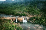 A panoramic view of multiple waterfalls flowing into a serene valley.